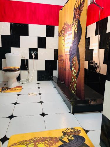 a bathroom with a black and white tiled floor at Petite Flower Guest House in Talata-maty