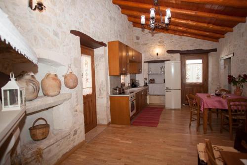a large kitchen with a table and a refrigerator at Ariadne Traditional Home in Margarítai