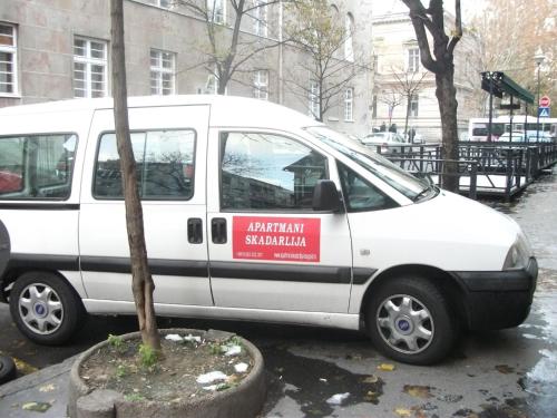 a white van is parked next to a tree at Apartments Skadarlija in Belgrade