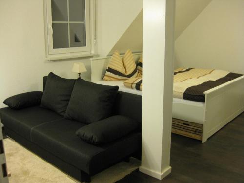 a living room with a couch and a bed at Ferienwohnung David in Winterberg