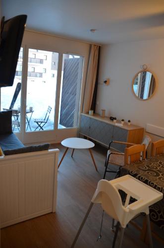 - un salon avec vue sur un balcon dans l'établissement Pied de pistes, résidence 3 étoiles tout confort dont terrasse et piscine, à Valmeinier