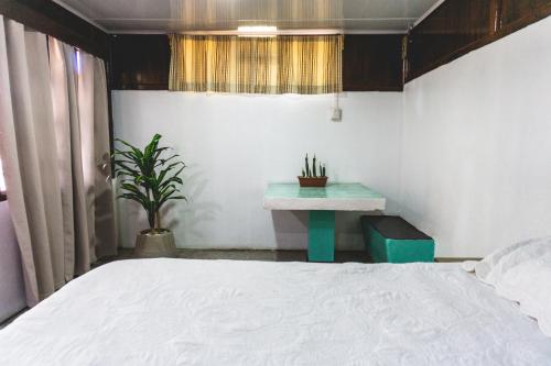 a bedroom with a bed and a table with a plant at Cabinas EL PRADO in San Isidro