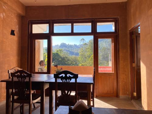 a dining room with a table and a large window at Queensark in Adams Peak