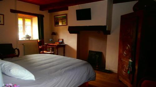 1 dormitorio con 1 cama y 1 habitación con ventana en L'Apothéis, en Saint-Thégonnec