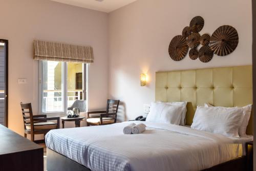 a bedroom with a large bed with two stuffed animals on it at Aurum Resorts Morjim in Morjim