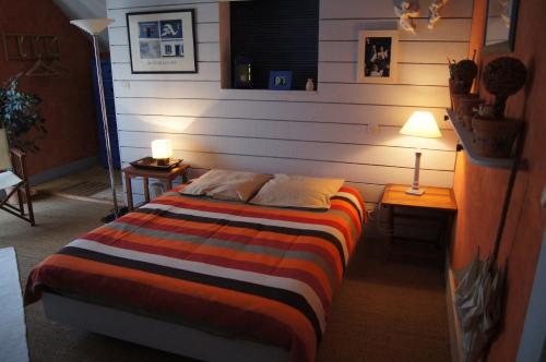 1 dormitorio con 1 cama, 2 mesas y 1 lámpara en Ô 156, en Saint-Georges-sur-Cher