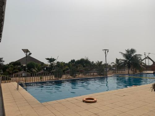 a large swimming pool with a raft in the middle at Marcelo Beach Club in Lomé