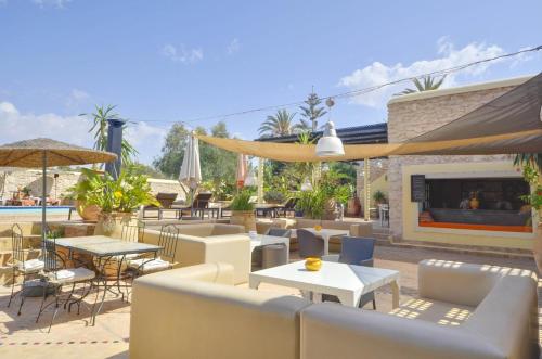 a patio with tables and chairs and a fireplace at Essaouira Lodge in Essaouira