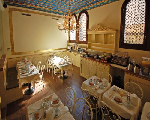 una cucina con tavoli, sedie e un grande schermo di Hotel Torino a Venezia