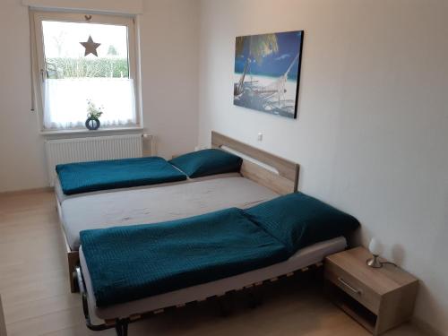 two twin beds in a room with a window at Ferienwohnung Landluft in Ostercappeln