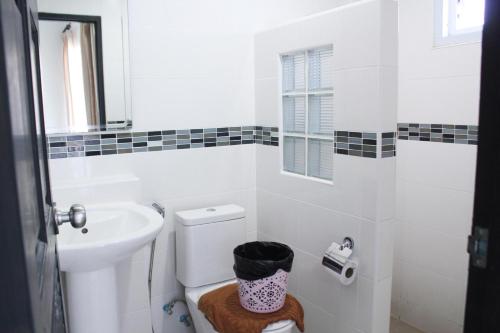 uma casa de banho branca com um lavatório e um WC em Plus Hotel em Loei