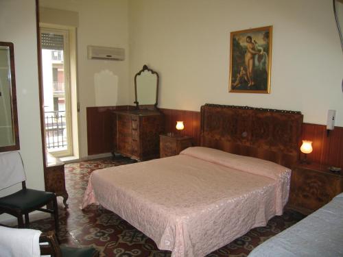 een slaapkamer met een bed, een dressoir en een spiegel bij Hotel Touring in Messina