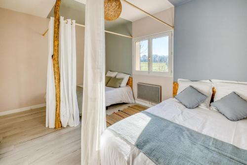 a bedroom with a white bed and a window at Le Grand Cottage Nature Piscine Chauffée Privée du Tarn entre Toulouse et Albi & Les Cottages du Tarn in Peyrole