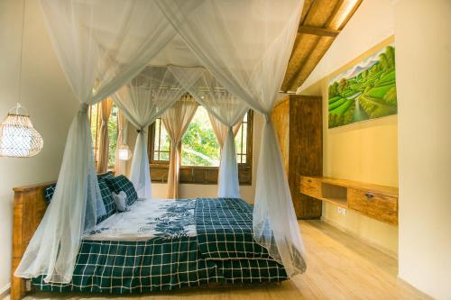 een slaapkamer met een hemelbed bij Yoga Maya Villa in Gianyar