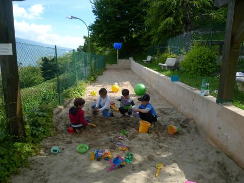 three children playing in the sand in a sandbox at Village Hotel Lucia in Tremosine Sul Garda