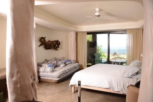 a bedroom with a bed and a large window at Nayara Hangaroa in Hanga Roa