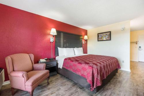 a hotel room with a bed and a chair at Econo Lodge Waynesville in Waynesville