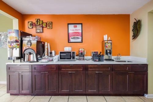 a kitchen with an orange wall and a counter top at Econo Lodge Waynesville in Waynesville