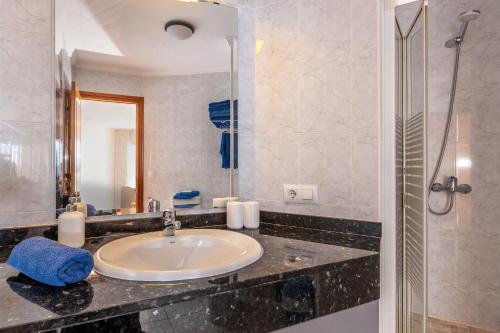 ein Bad mit einem Waschbecken und einem Spiegel in der Unterkunft Residencial Playa Mar in Cala Mendia