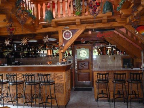 a bar with bar stools in a restaurant at Napkorong Fogadó és Vendégház in Piliscsaba