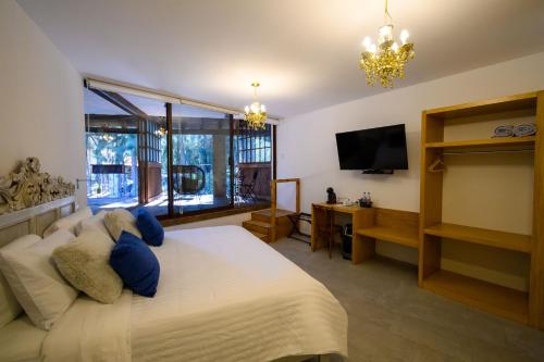 a bedroom with a large bed and a television at Villa Toscana ValQuirico Lofts & Suites Hotel Boutique in Santeagueda