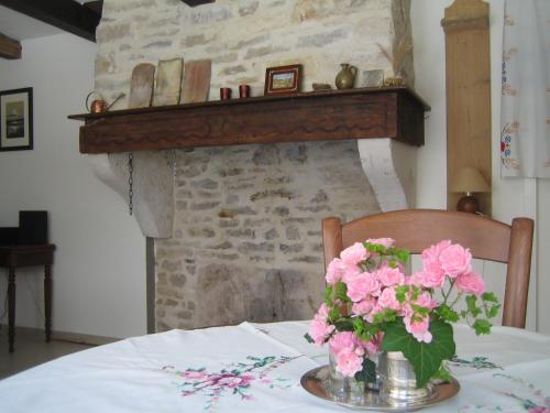 einen Tisch mit einer Vase rosa Blumen drauf in der Unterkunft Bévau - B&B bio 