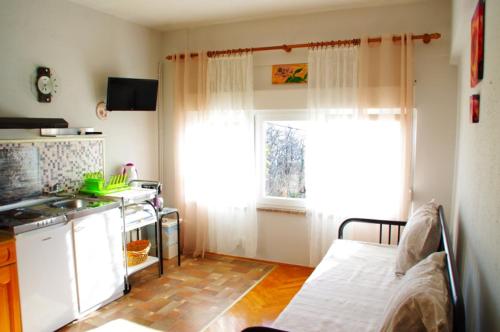 uma pequena cozinha com uma cama e uma janela em Apartment Matea em Matulji