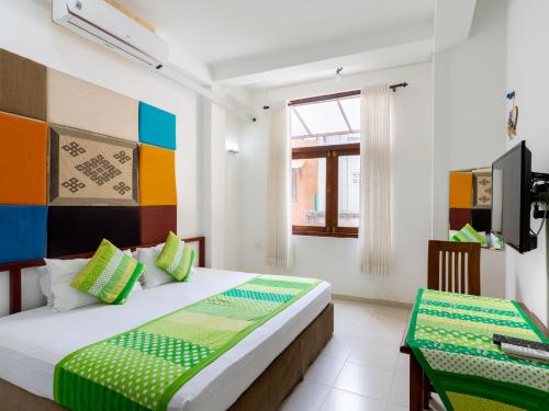 1 dormitorio con 1 cama y TV en White Fortress en Sri Jayewardenepura Kotte
