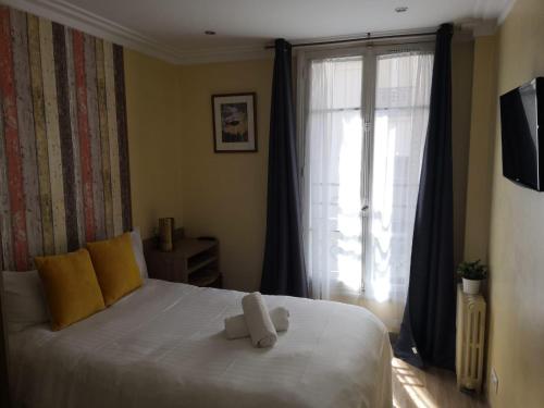 Un dormitorio con una cama con dos ositos de peluche. en Hôtel Roi René en París