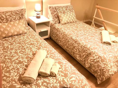 a bedroom with two beds with towels on it at Borgo Empedocle House in Catania