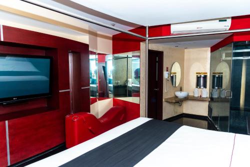1 dormitorio con 1 cama grande y TV en DLUXE Auto Hotel ADULTS ONLY en Veracruz