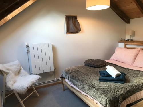 1 dormitorio pequeño con 1 cama y 1 silla en Appartement Duplex avec Jardin Attenant, en Briançon