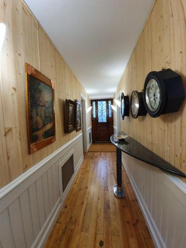 a hallway with wooden walls and a clock on the wall at LE 41 AVENUE FOCH in Luchon