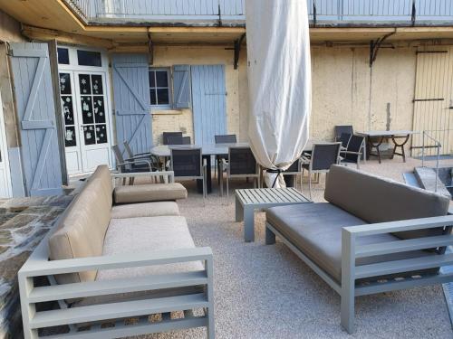 a patio with couches and tables and a umbrella at LE 41 AVENUE FOCH in Luchon
