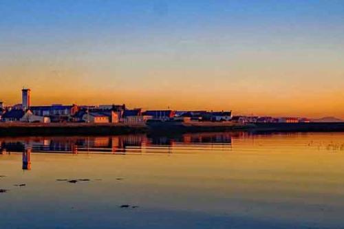 a view of a city from the water at sunset at Barbers Hall Apartment Town Center in Belmullet