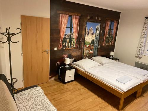 チェルニー・ドゥールにあるApartmány Viktorkaのベッドルーム1室(大型ベッド1台、木製ヘッドボード付)