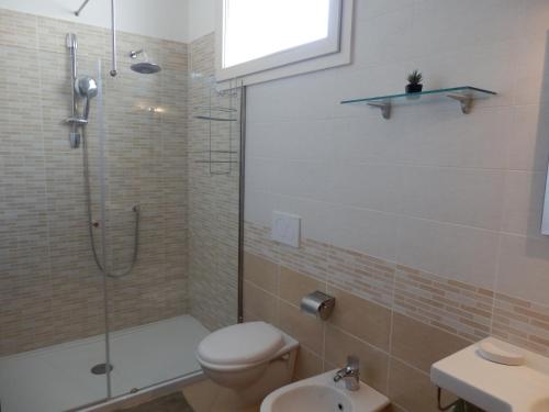 a bathroom with a shower and a toilet and a sink at Casa Lauretta - terrazza con idromassaggio - garage wifi e bici gratuite in Lecce