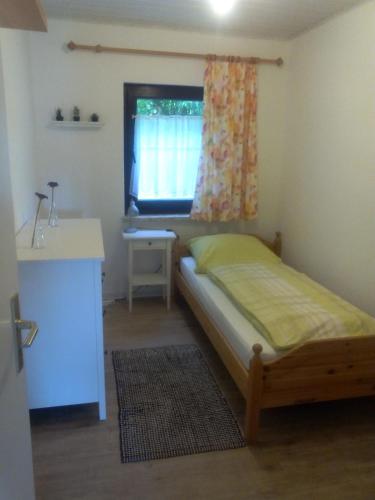 a bedroom with a bed and a sink and a window at FeWo Gelnhausen in Gründau