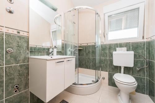 e bagno con doccia, servizi igienici e lavandino. di Apartments Danijela 2 a Sukošan (San Cassiano)
