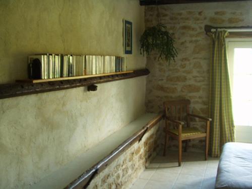 a room with a bench and a chair and a book shelf at Le Charbonnet in Anzy-le-Duc