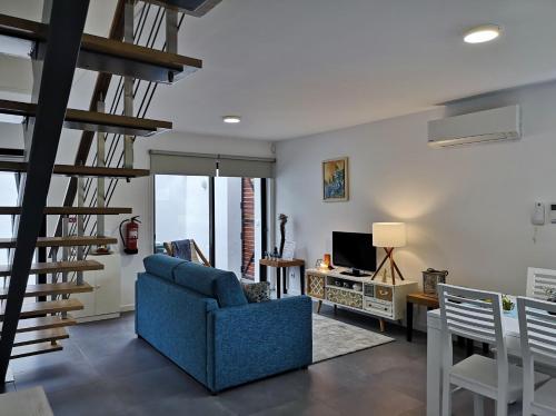 a living room with a blue couch and a staircase at Furnas Springs in Furnas