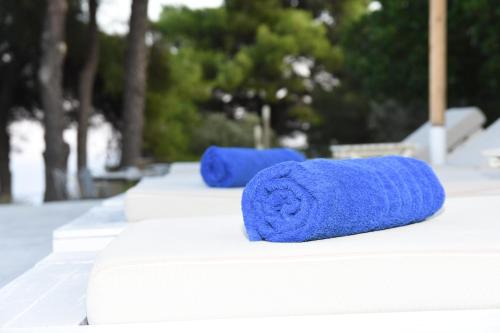 twee rollen blauwe handdoeken zittend op een tafel bij Entechnos Living in Skiathos-stad