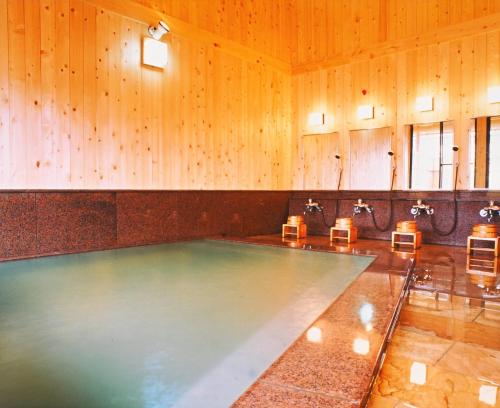 una piscina in una stanza con pareti in legno di Shibu Hotel a Yamanouchi