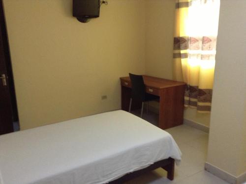 a bedroom with a desk and a bed and a table at Hotel Cristina in Bocas Town
