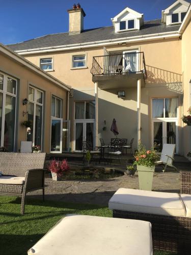 a large house with a patio and a balcony at Rossmanagher House in Bunratty