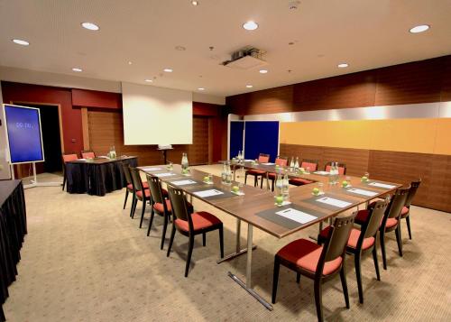 ein großer Konferenzraum mit einem langen Tisch und Stühlen in der Unterkunft Hotel Wemperhardt in Wemperhardt