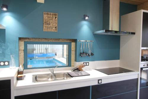 une cuisine avec un évier et une piscine dans l'établissement Gite L'Hermine, à Azay-le-Rideau