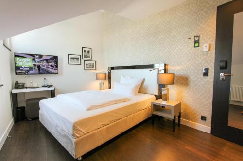 - une chambre avec un grand lit et un lavabo dans l'établissement Hotel Wemperhardt, à Wemperhardt