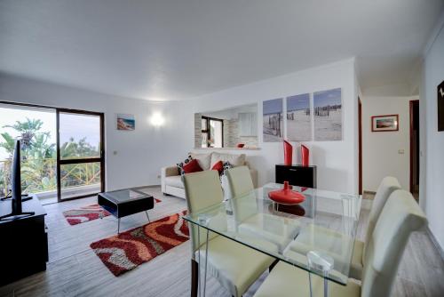 a living room with a glass table and chairs at PRAINHA BEACH APARTMENT in Luz
