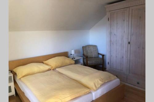 een bed met gele lakens en een stoel in een kamer bij Haus Altenburg in Innsbruck